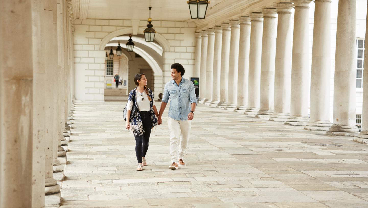 Couple walking through the Queen's House colonnades
