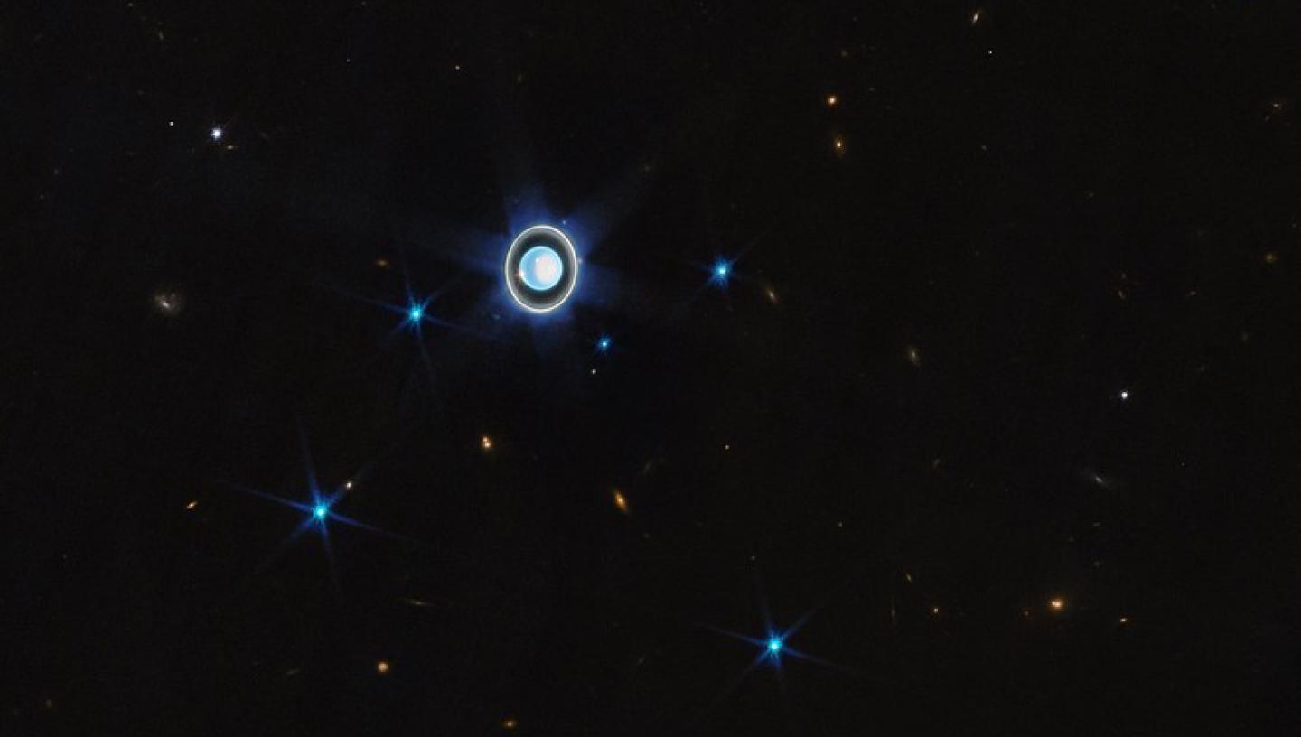 Image of blue round planet which is Uranus, with a blue ring around it 