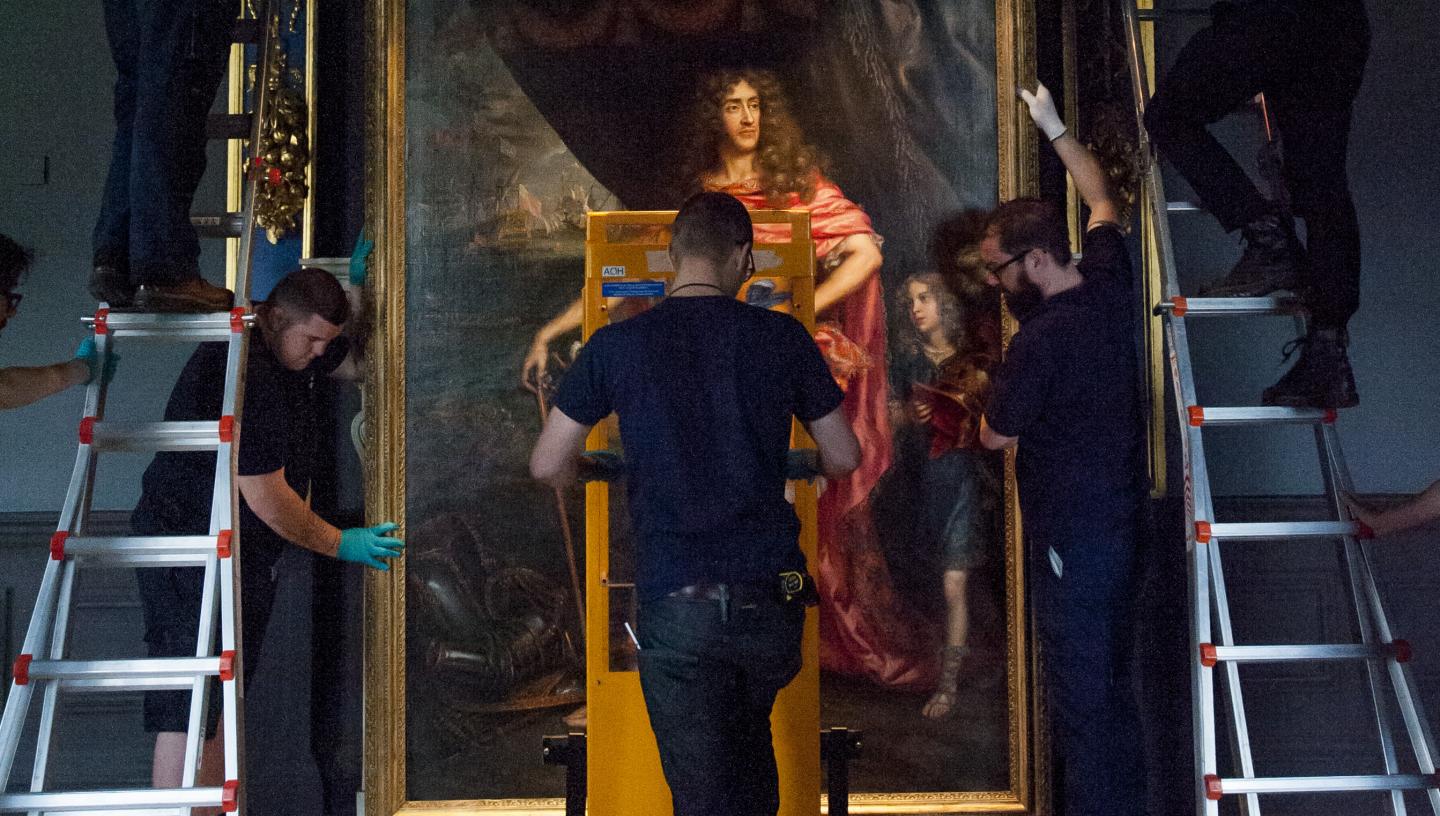 Art object handlers install a painting at the Queen's House 