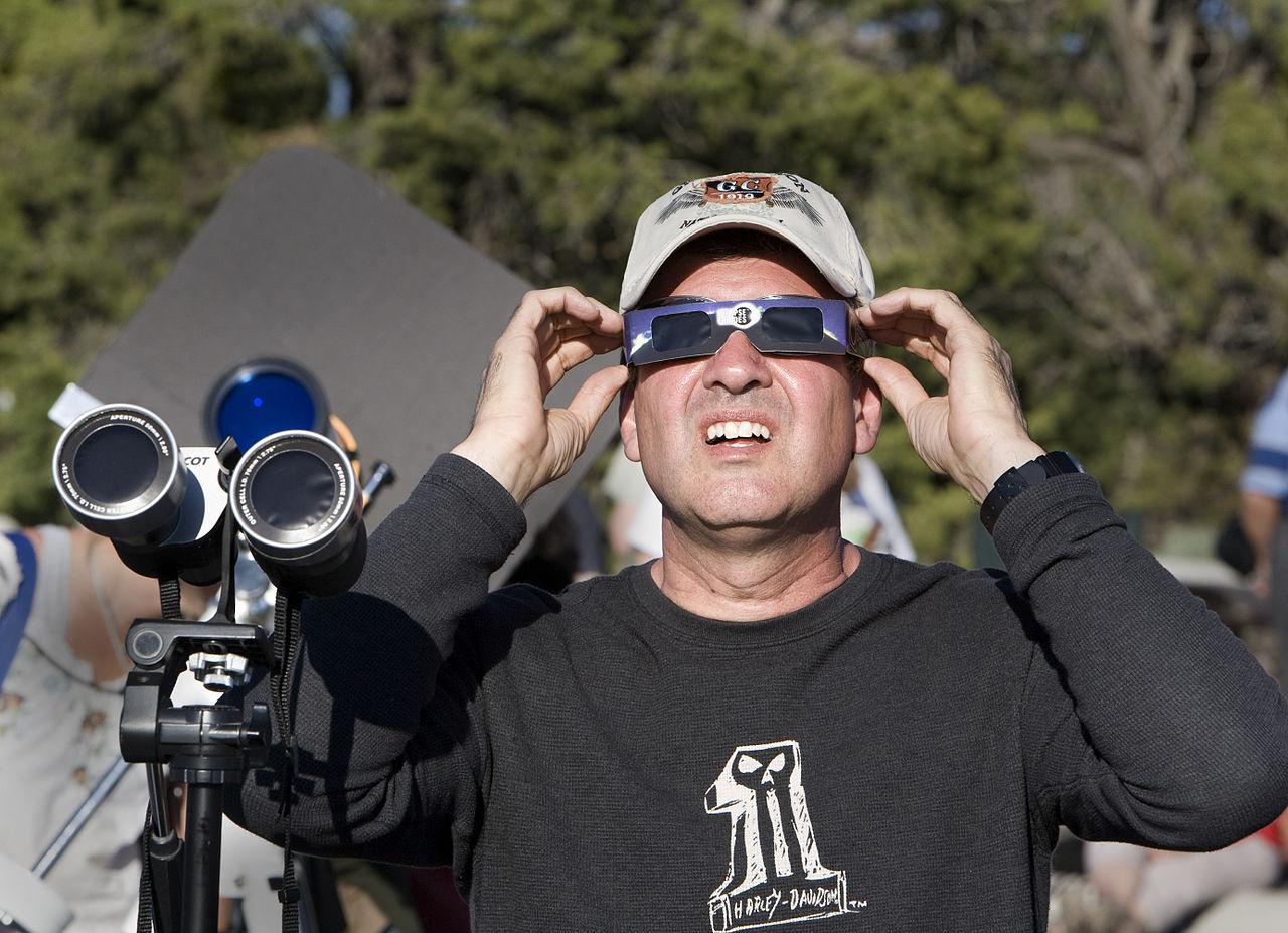 Photo of a man using safe eyewear to view a solar eclipse