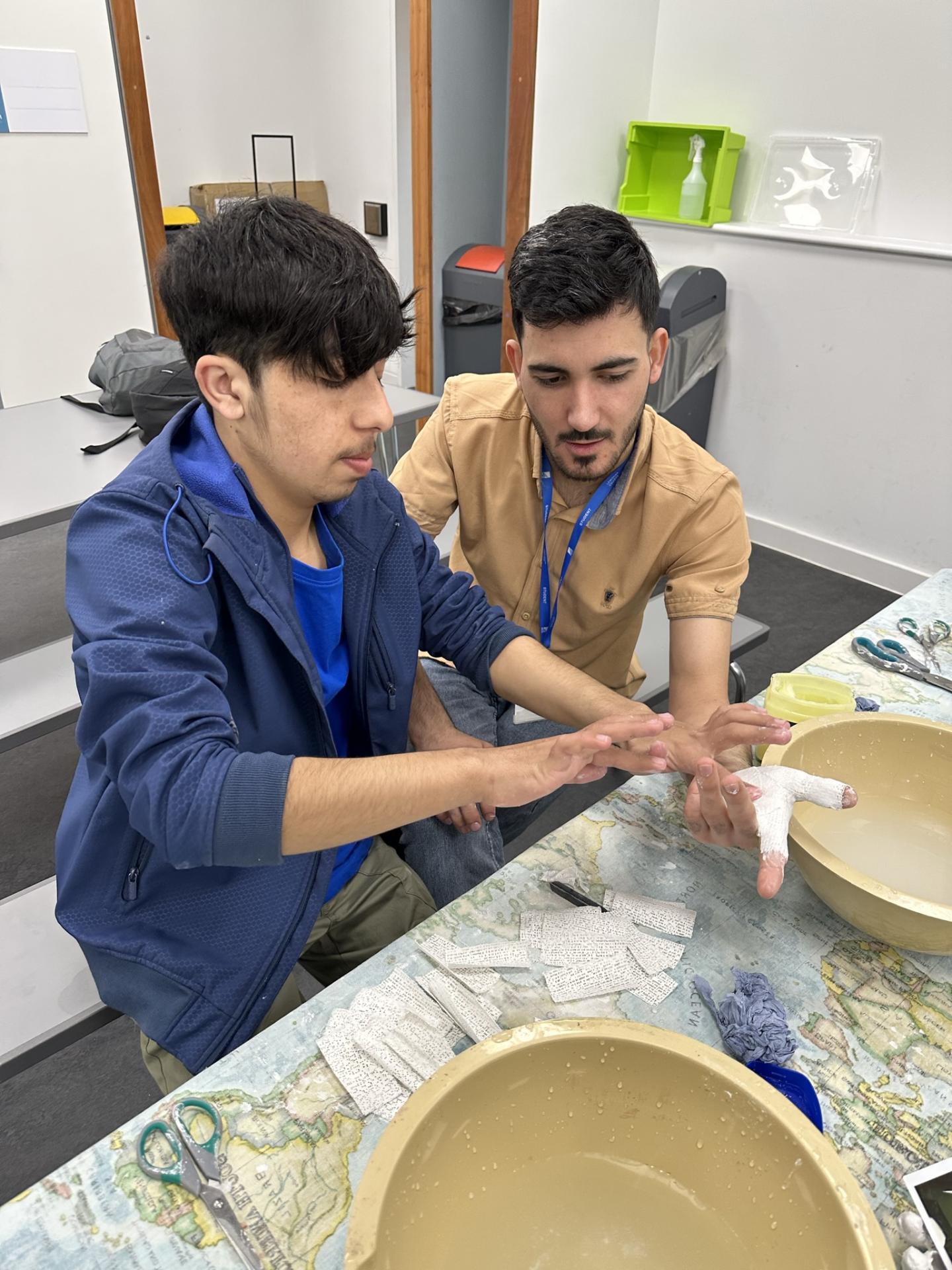 2 students making a cast of their hand