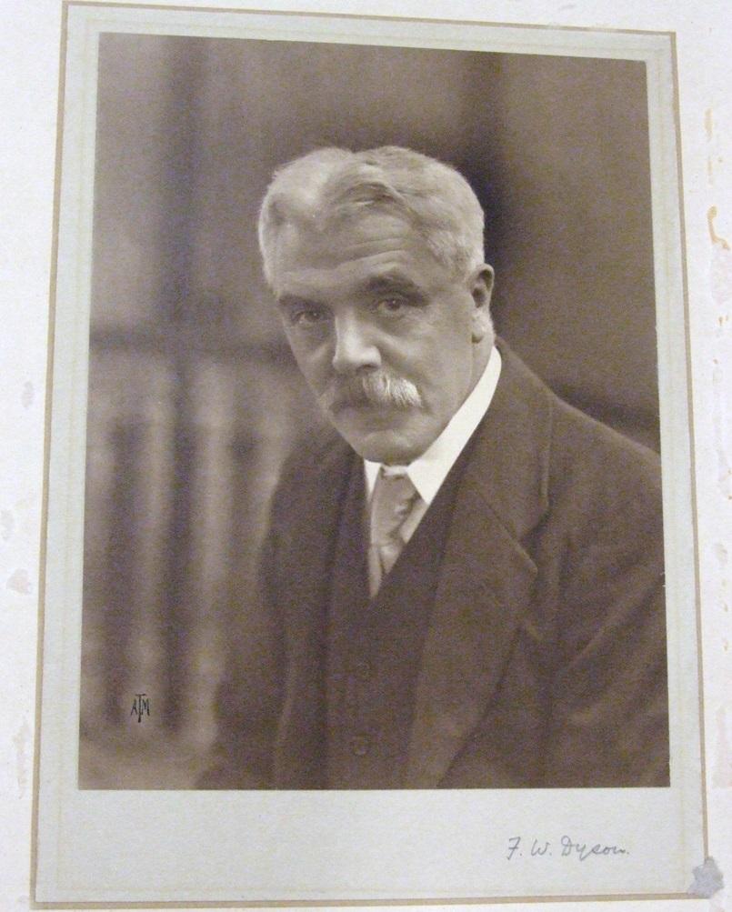 Sir Frank Watson Dyson, Astronomer Royal 1910-1933. Sepia photograph. The picture shows Sir Dyson's head and shoulders and has a plain background. He is leaning slightly forward, wearing shirt, tie and jacket, and has a moustache.