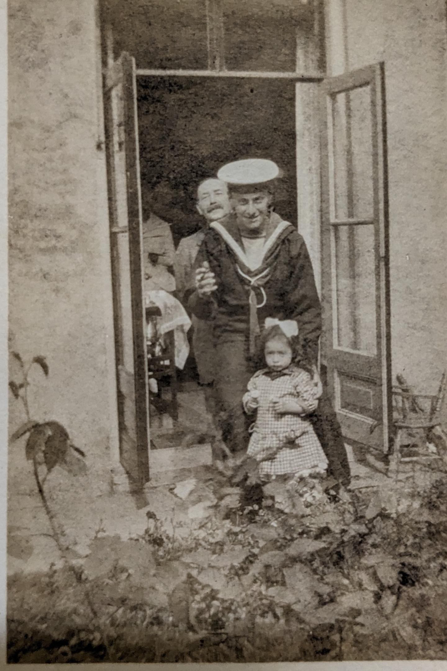 Old photograph of Ernest Edwin Russell and his family standing in the doorway to the garden.