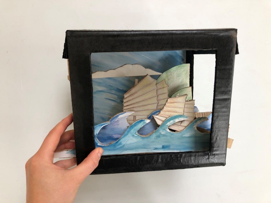 Bring your theatre to life A scene has been created of a ship behind waves, inside a cardboard box.