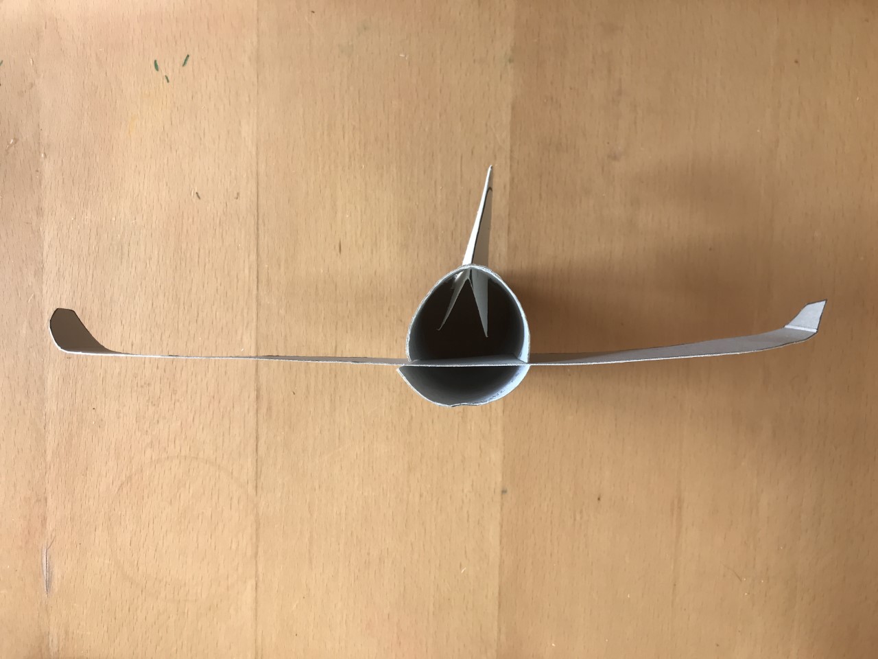 Make cuts and slot in the wings A birds eye view of a loo roll tube. A piece of card has been slotted into two cuts to look like wings.