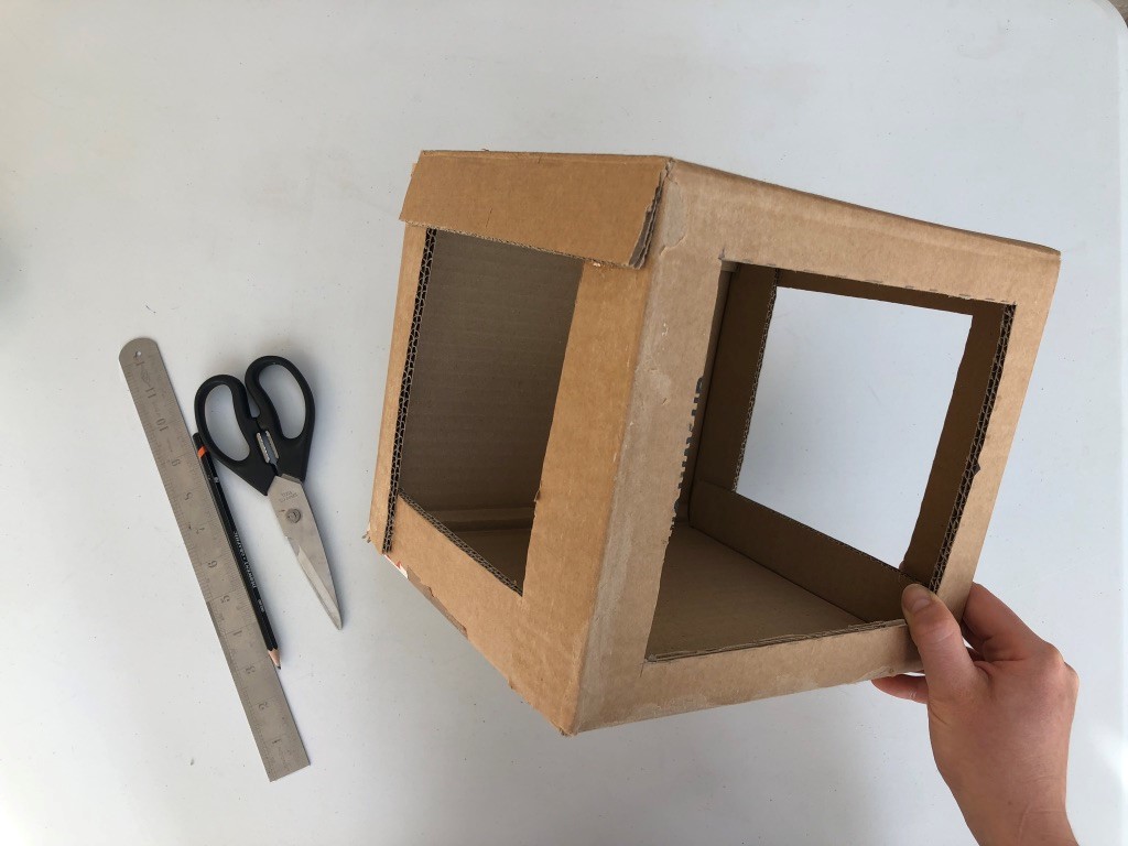 Build your theatre A cardboard box has three large sqaures cut into three sides, creating windows.