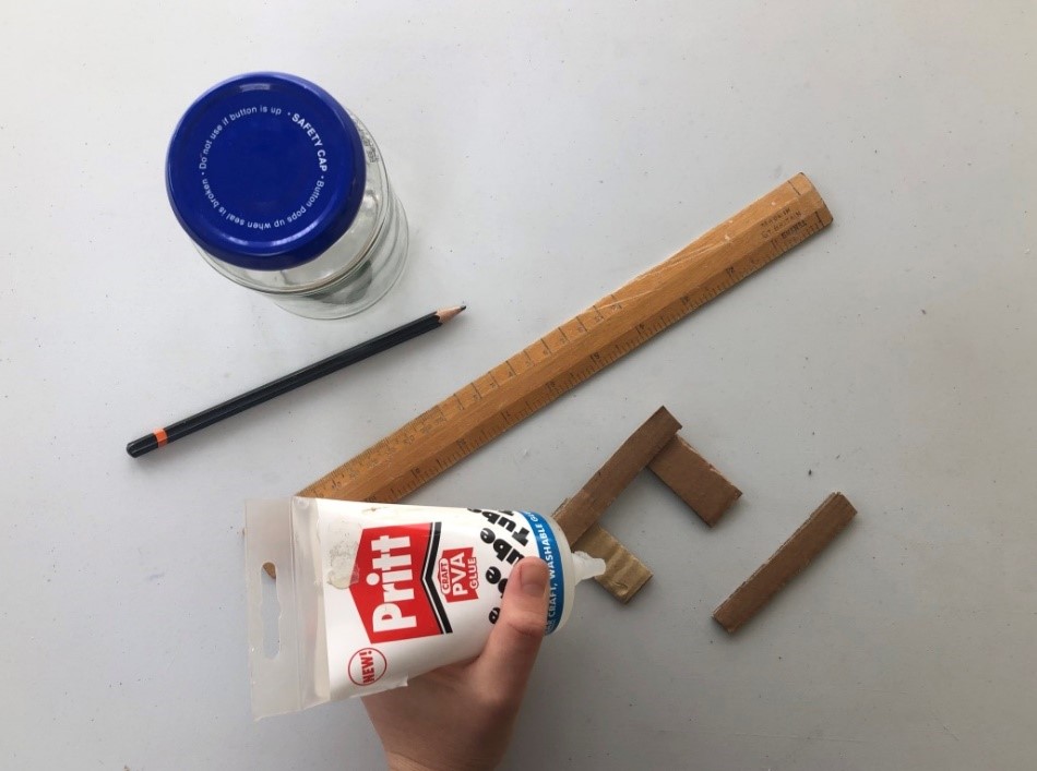 Create a stand Using glue someone sticks two long and short pieces of cardboard together to form a rectangle shaped stand.
