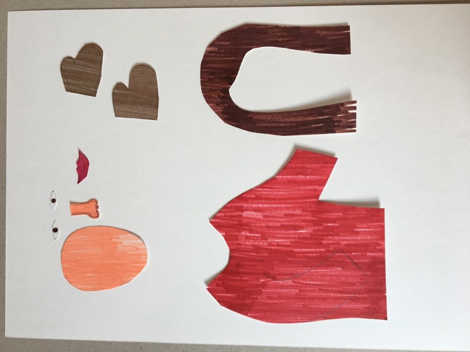 Draw your person and cut out the pieces Image shows drawings of bit of a person. A red shirt, long brown hair, grey glovesm two eyes, a nose, a mouth and a circle for the face have each been cut out seperately and placed on a piece of paper.