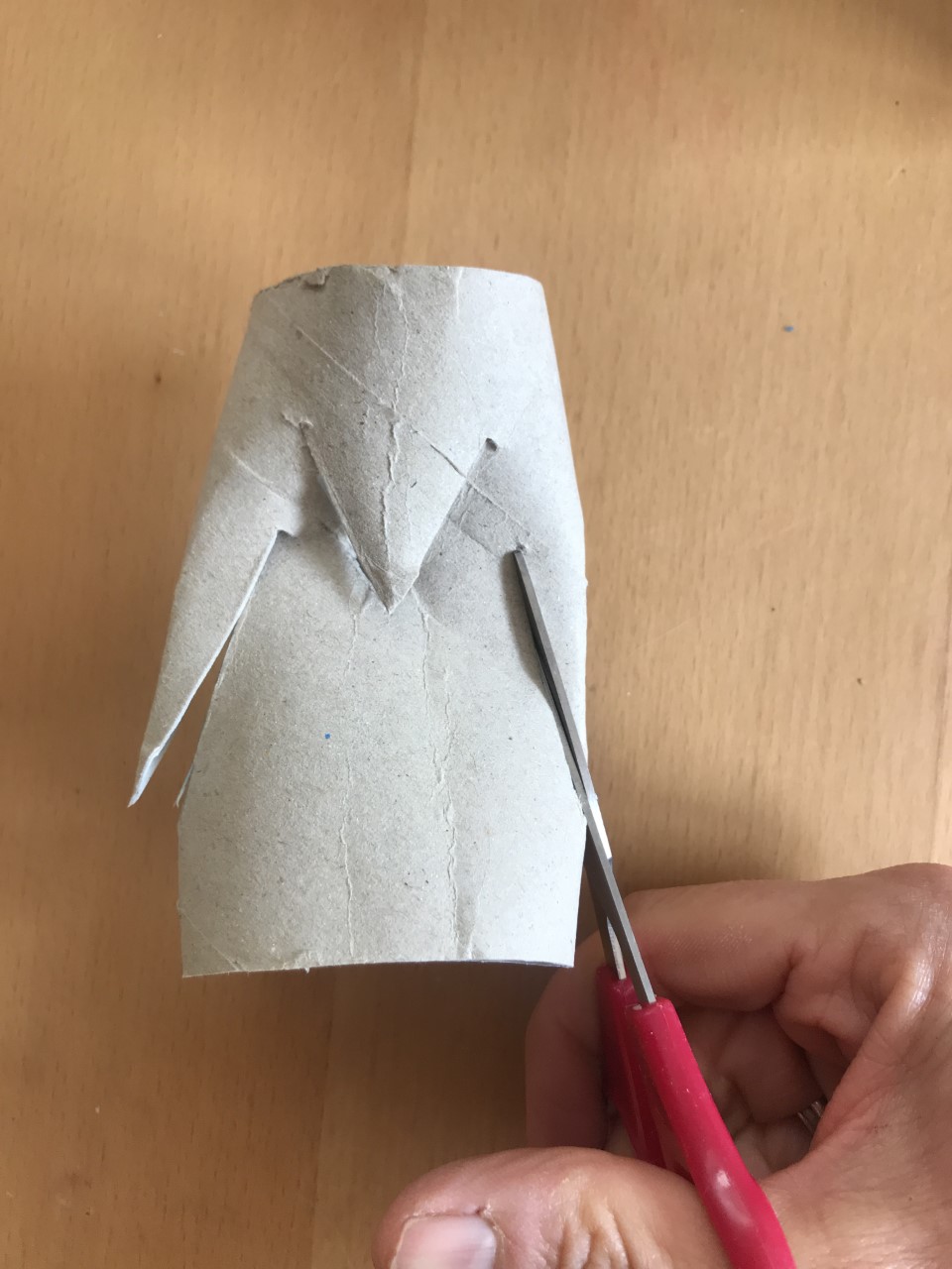 Make two more longer cuts A loo roll tube has two long cuts like wings and a small cut like a beak