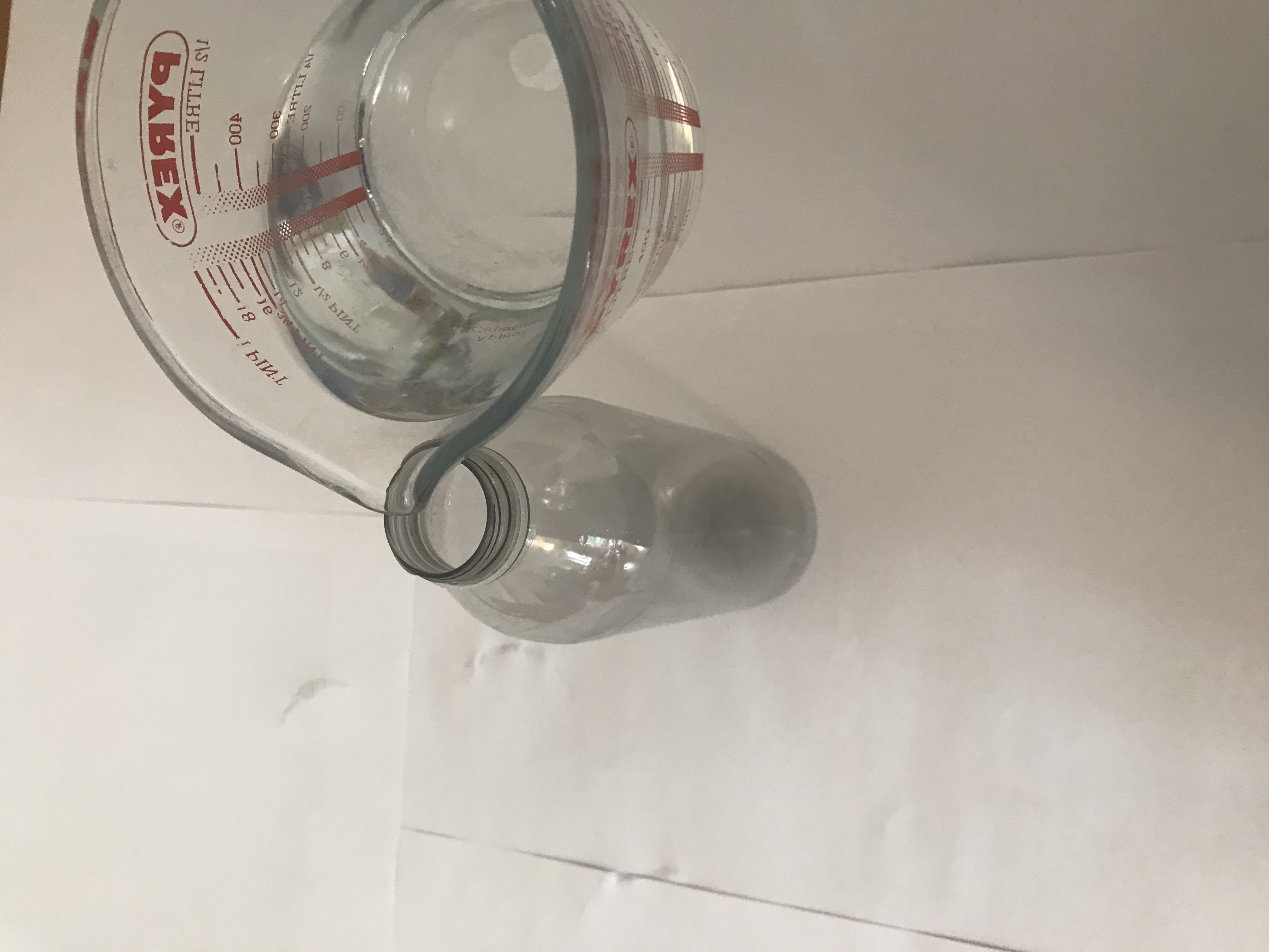 Add water to the bottle A plastic bottle has water added to it. The water comes just above the half way point.