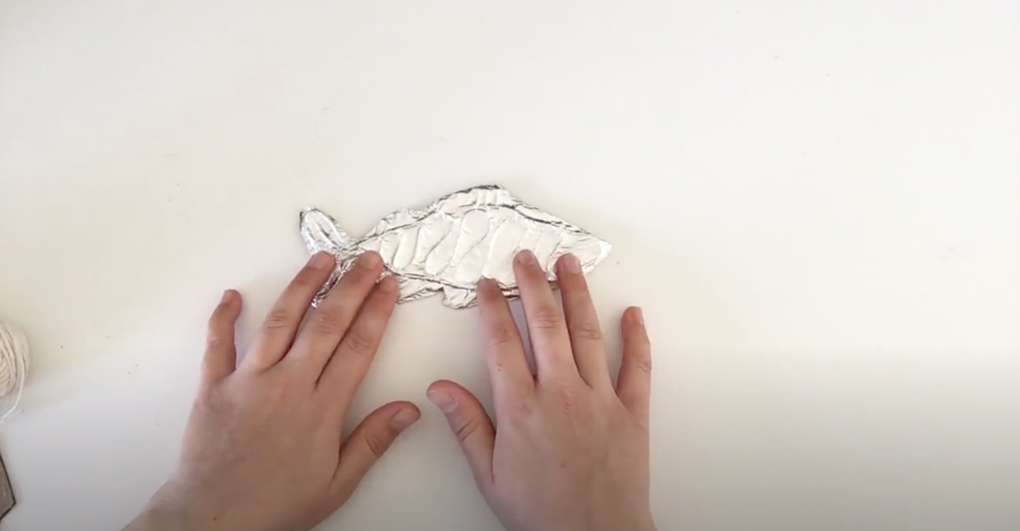 Image shows foil being pressed onto fish Image shows foil being pressed onto fish