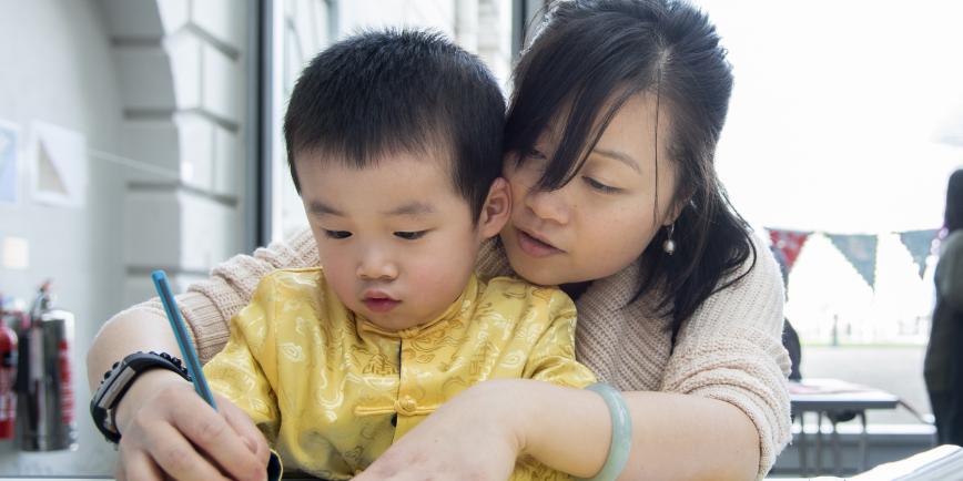 (Source of a mother helping the child to draw using a pencil Picture)