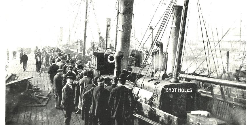 B&W postcard, man standing aboard a trawler