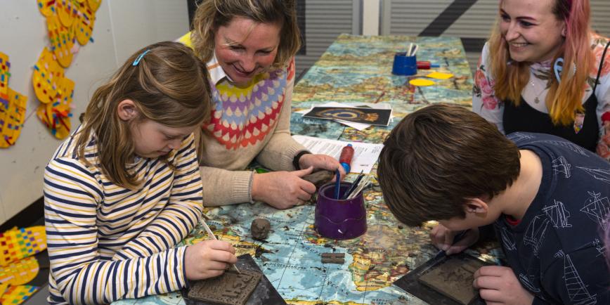 A group of four with adults and children participating in a craft.