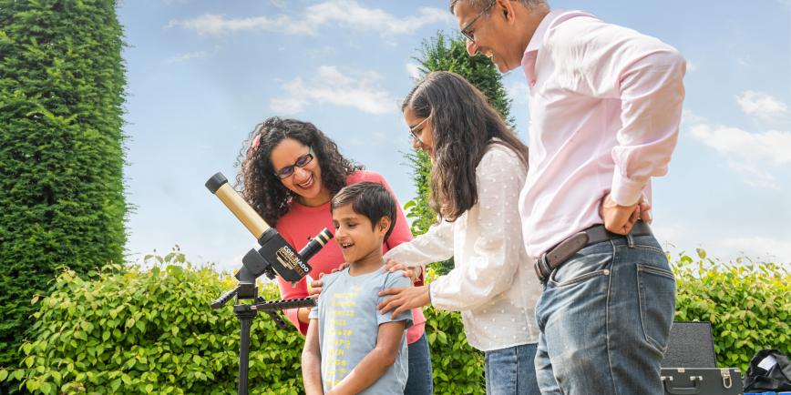 A family enjoy looking through a telescope during a science demonstration at the Royal Observatory