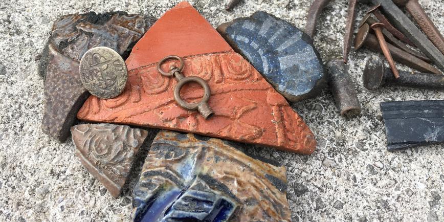 A selection of objects found while mudlarking on the River Thames, including shards of pottery, coins and metal nails