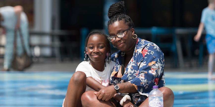 A mother and daughter sit on the Great Map during World Ocean Day at the National Maritime Museum
