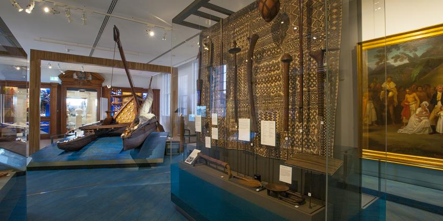 Photo of museum gallery with display of carved toki in the foreground