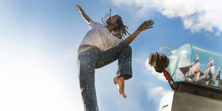 A dance leaps beside Nelson's Ship in a Bottle sculpture