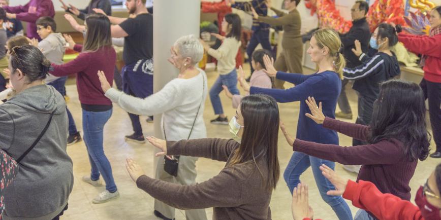 A group of people stretch their arms to the side