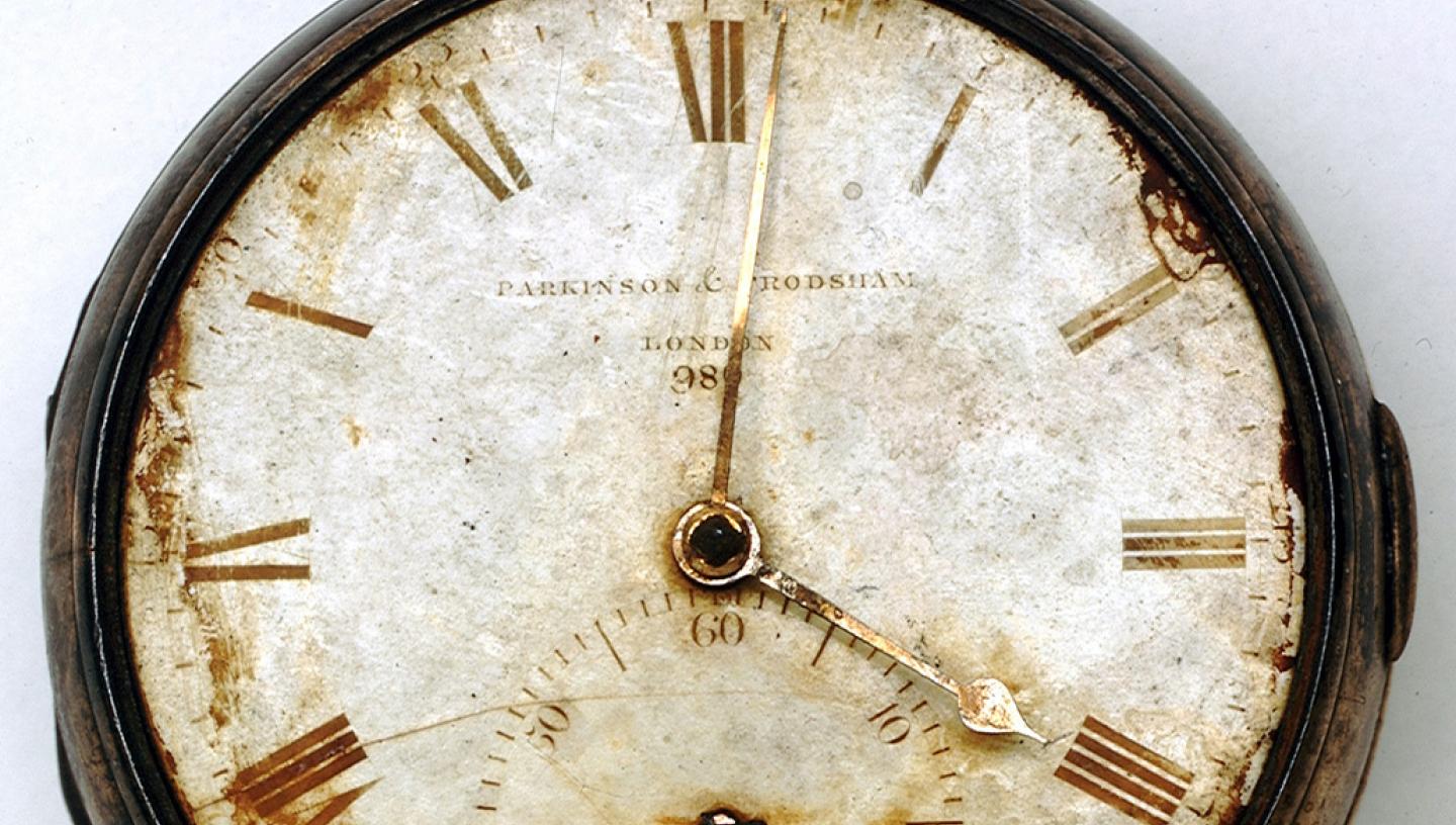 A rusted pocket watch or 'chronometer', with discoloured glass case and dials
