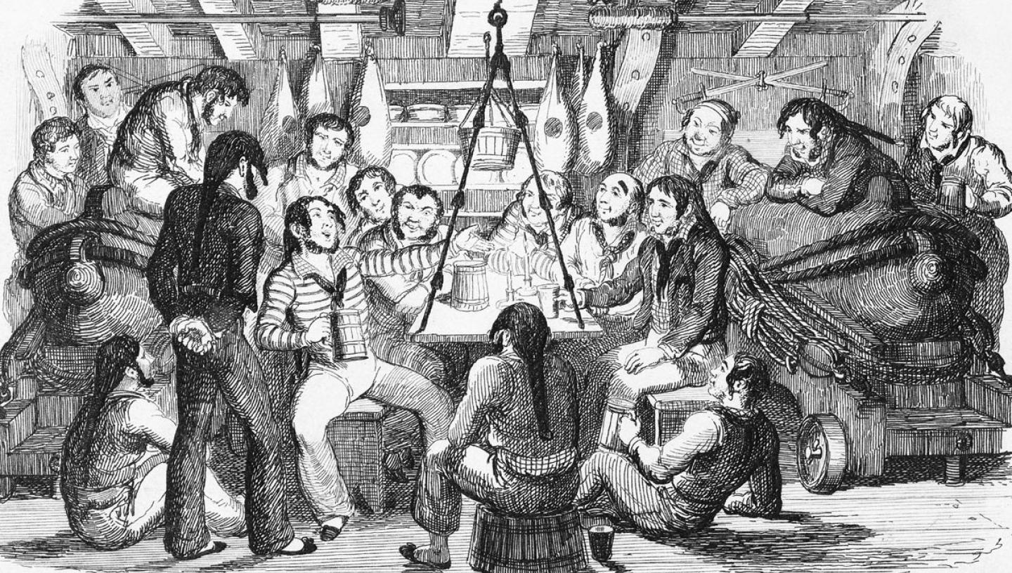 A black and white etching of a raucous scene below decks, with sailors sitting round a fireplace