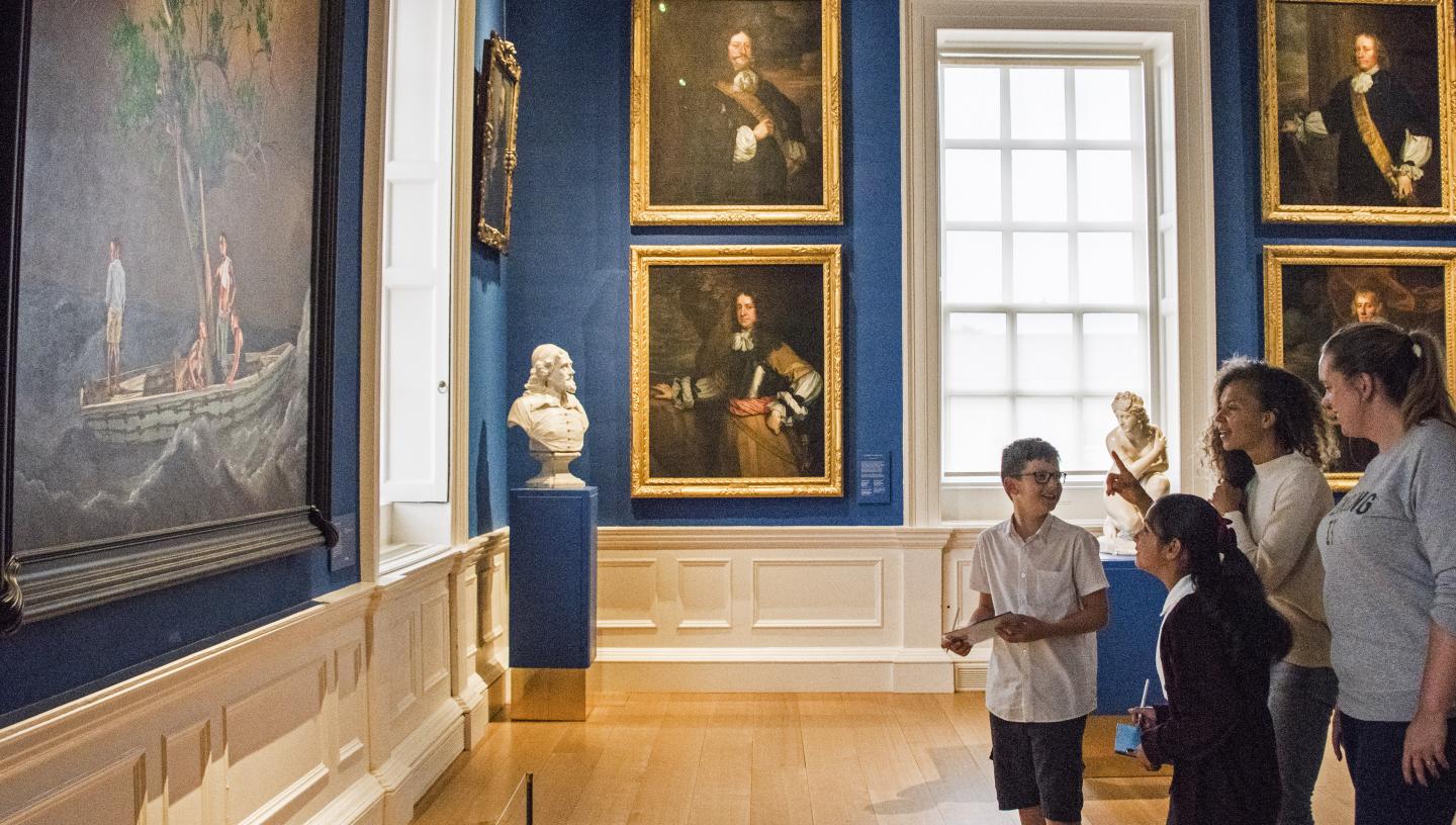 Two children and two adults look at a large image in the Queen's House.