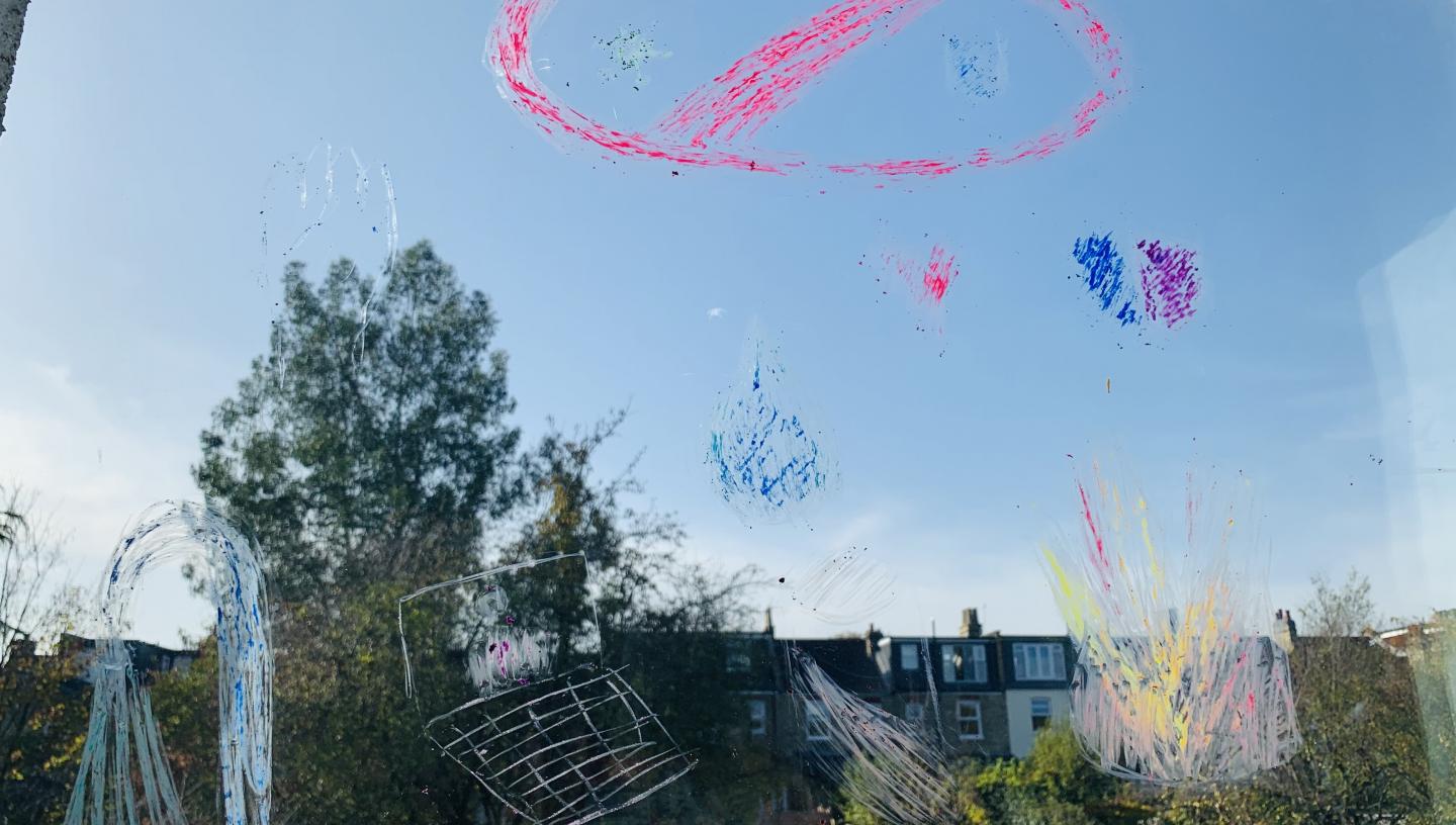 A drawing on a window that looks over a garden