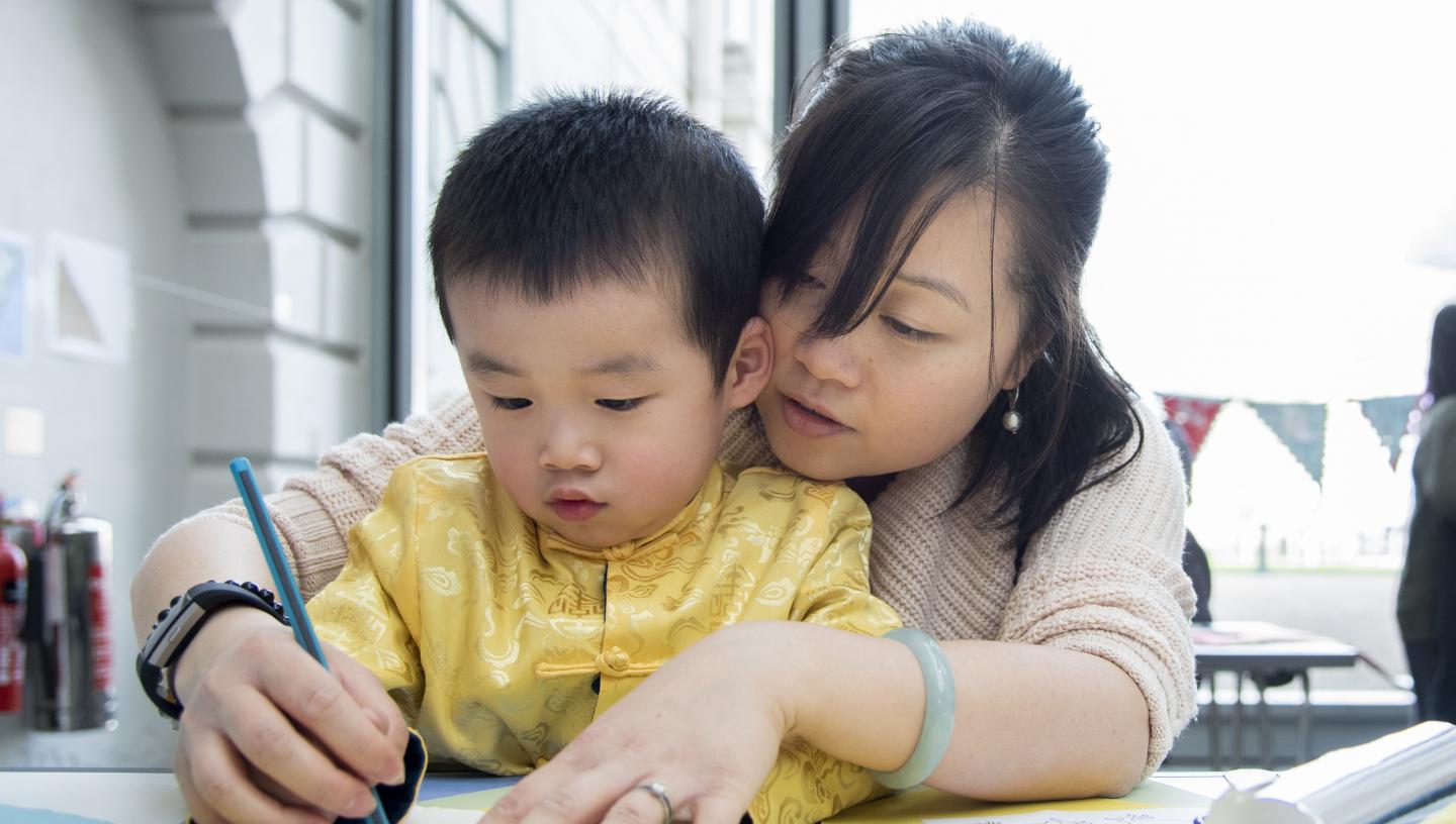 (Source of a mother helping the child to draw using a pencil Picture)