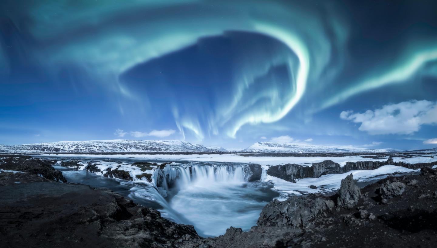 Blue aurorae over a waterfall in Iceland