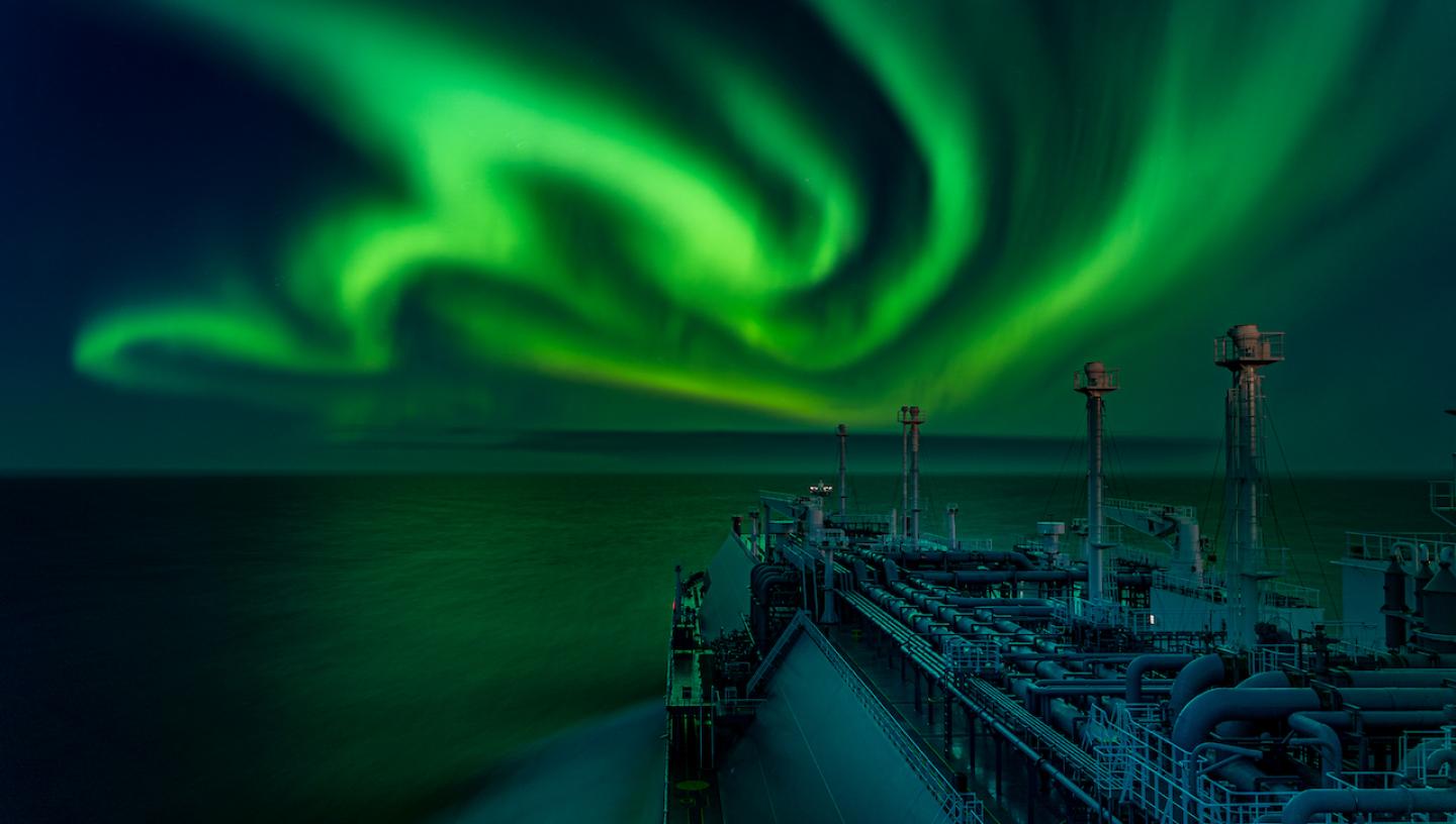 A green aurora curtain above a ship at sea