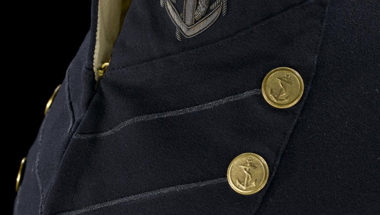 The front of a Royal Navy surgeon's full dress coat from the 19th century. A stylish anchor motif is shown on the collar and buttons