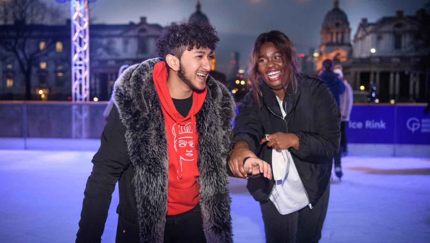 Two young people holding hands and smiling at the Queen's House Ice Rink