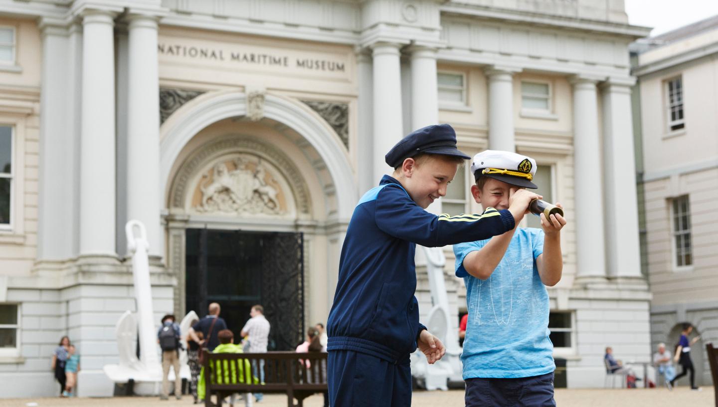 (source of two children holding a binoculars in front of romney entrance at NMM picture)