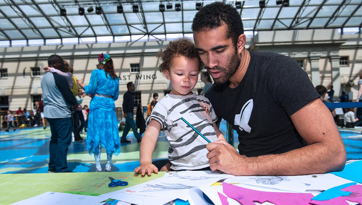 A father takes part in a craft activity with his son during a World Oceans Day Museums workshop