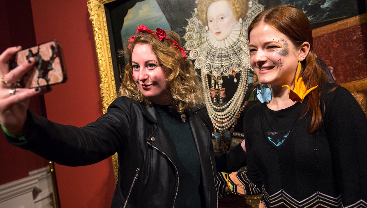 Two women take a selfie in front of the Armada Portrait of Elizabeth I at the Queen's House