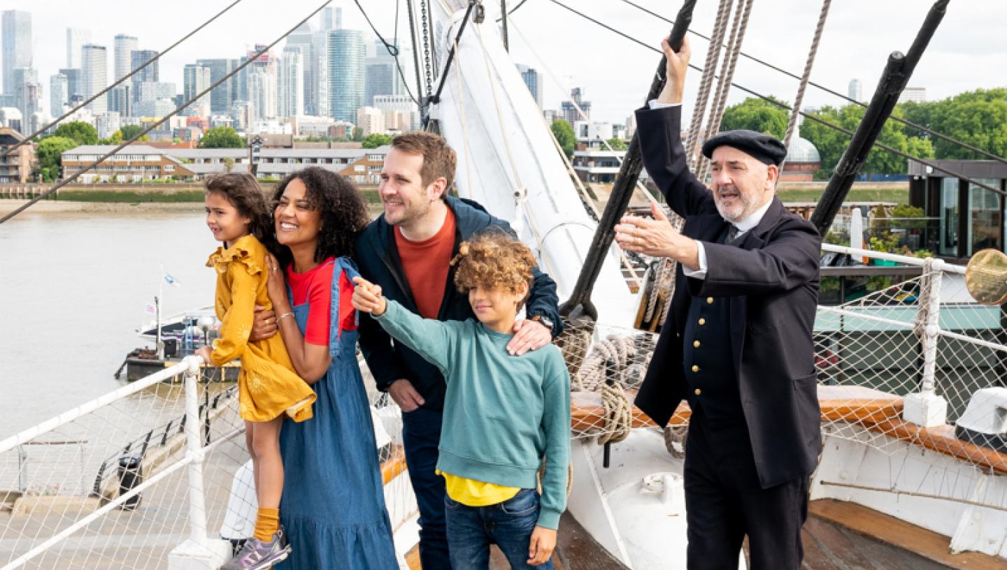 A family on the deck of Cutty Sark with a man dressed as Captain Woodget