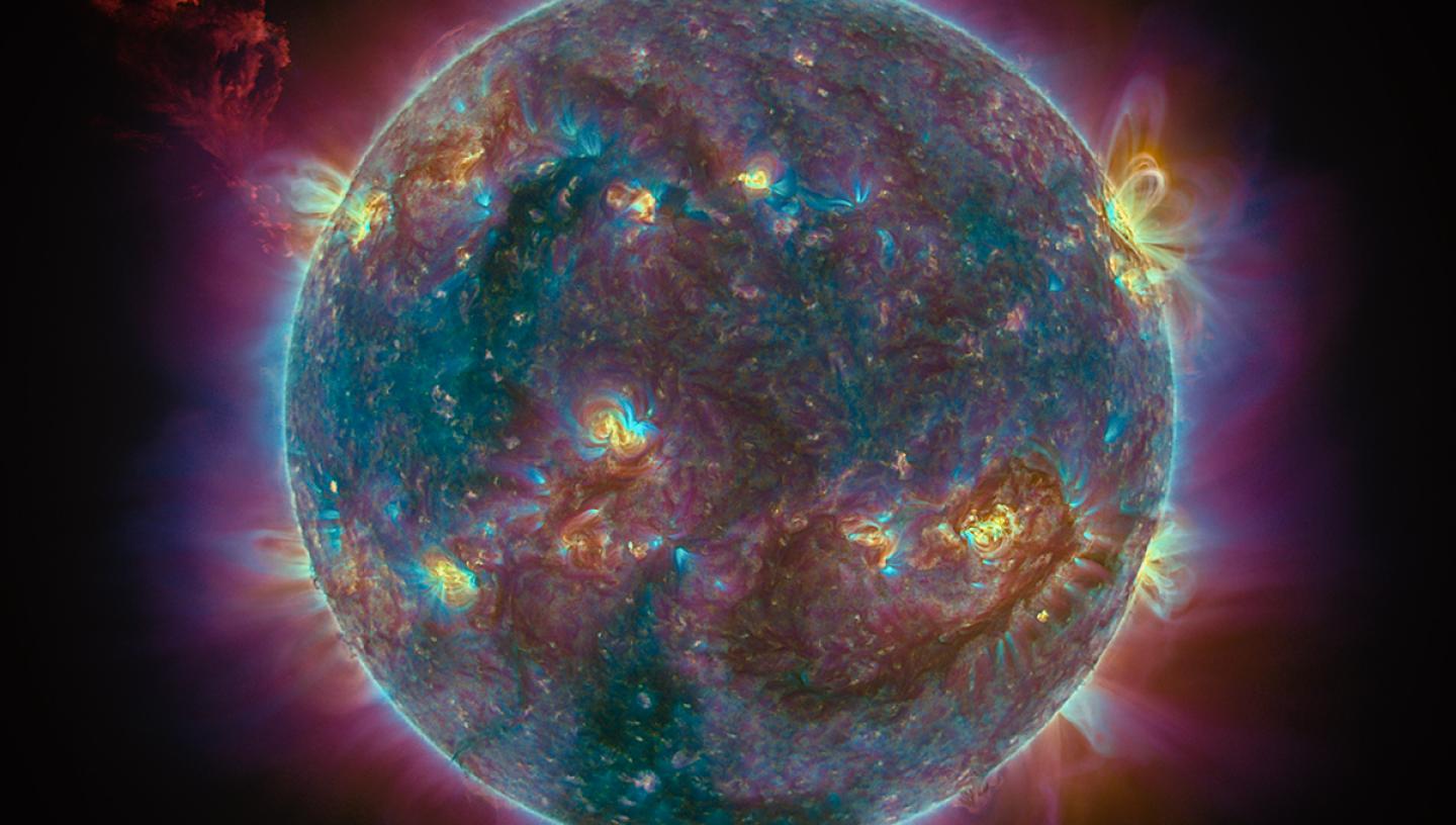 Image showing busy surface and coronal activity of the Sun, in blue and purple tone