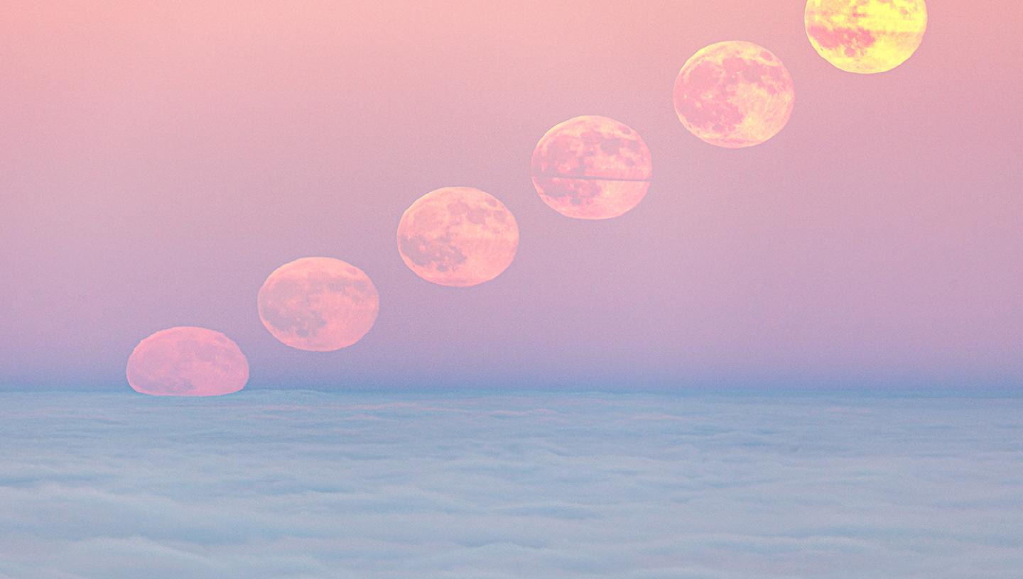 A photo combining multiple photos of the Moon as it rises in a pink sky