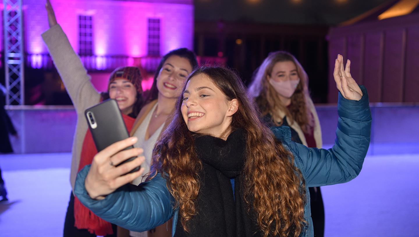 A group of young women take a selfie at the Queen's House Ice Rink
