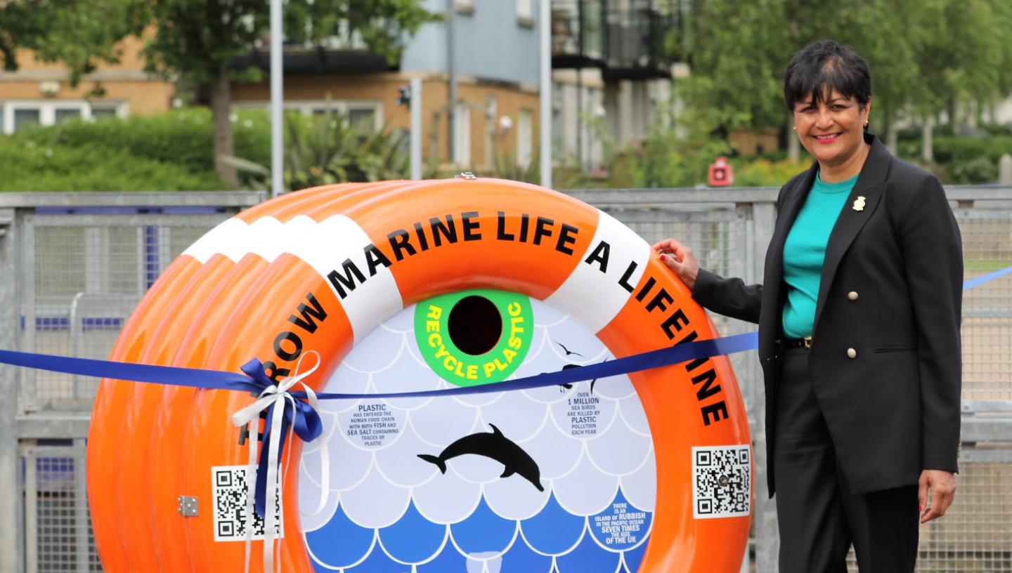 Fazilette Khan stands in front of orange bin