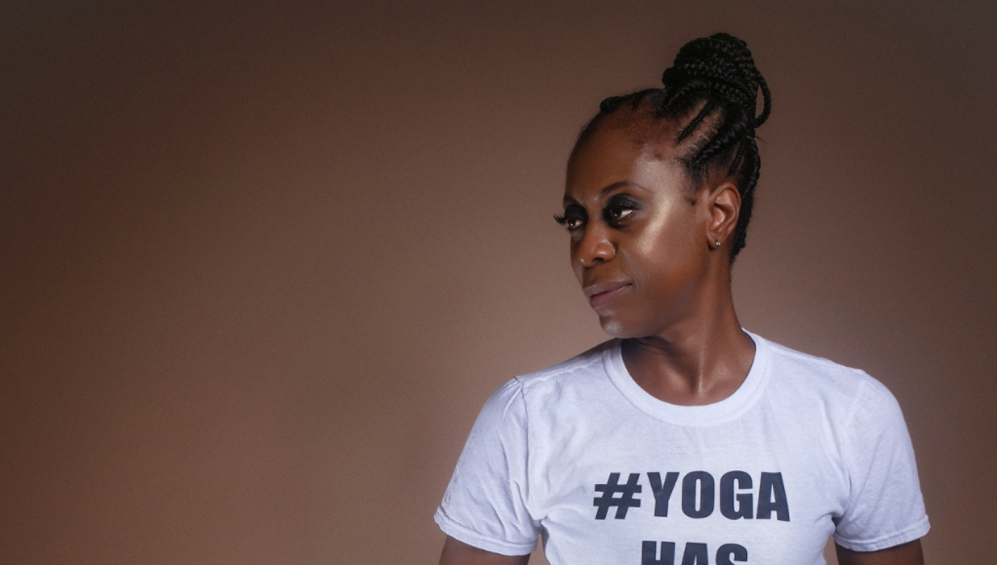Woman wearing white t-shirt which says #Yoga has no size