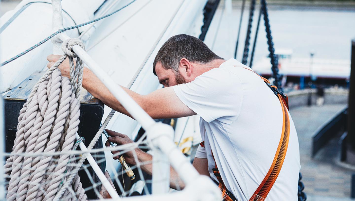A shipkeeper works on historic ship Cutty Sark