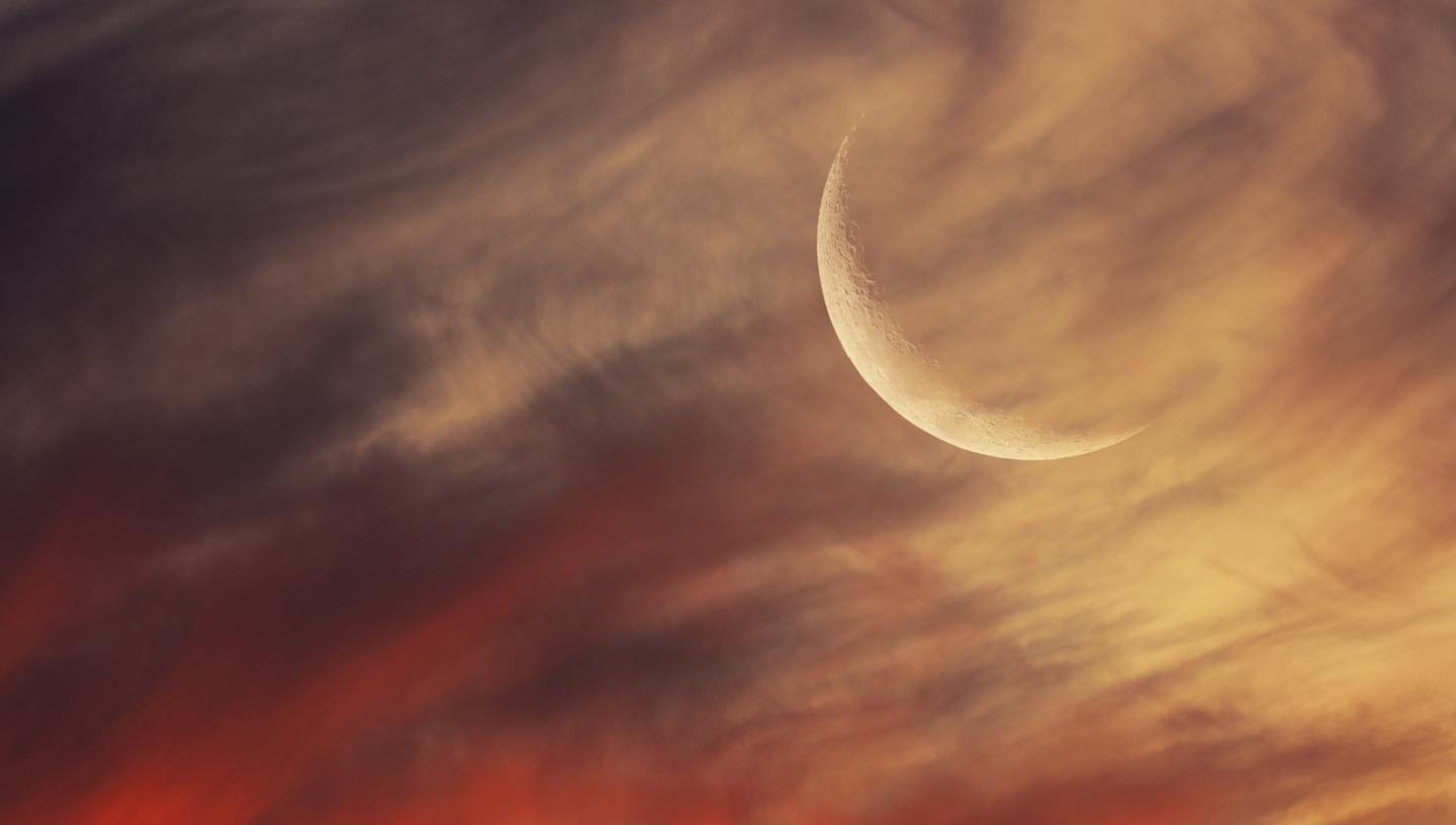Crescent Moon in a red and cream cloudy sky