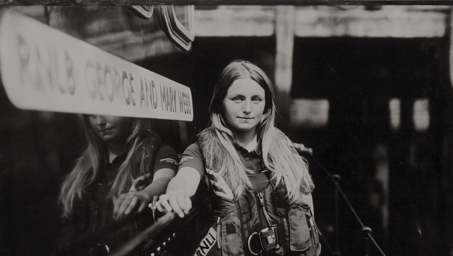 Black and white image of a woman wearing RNLI gear