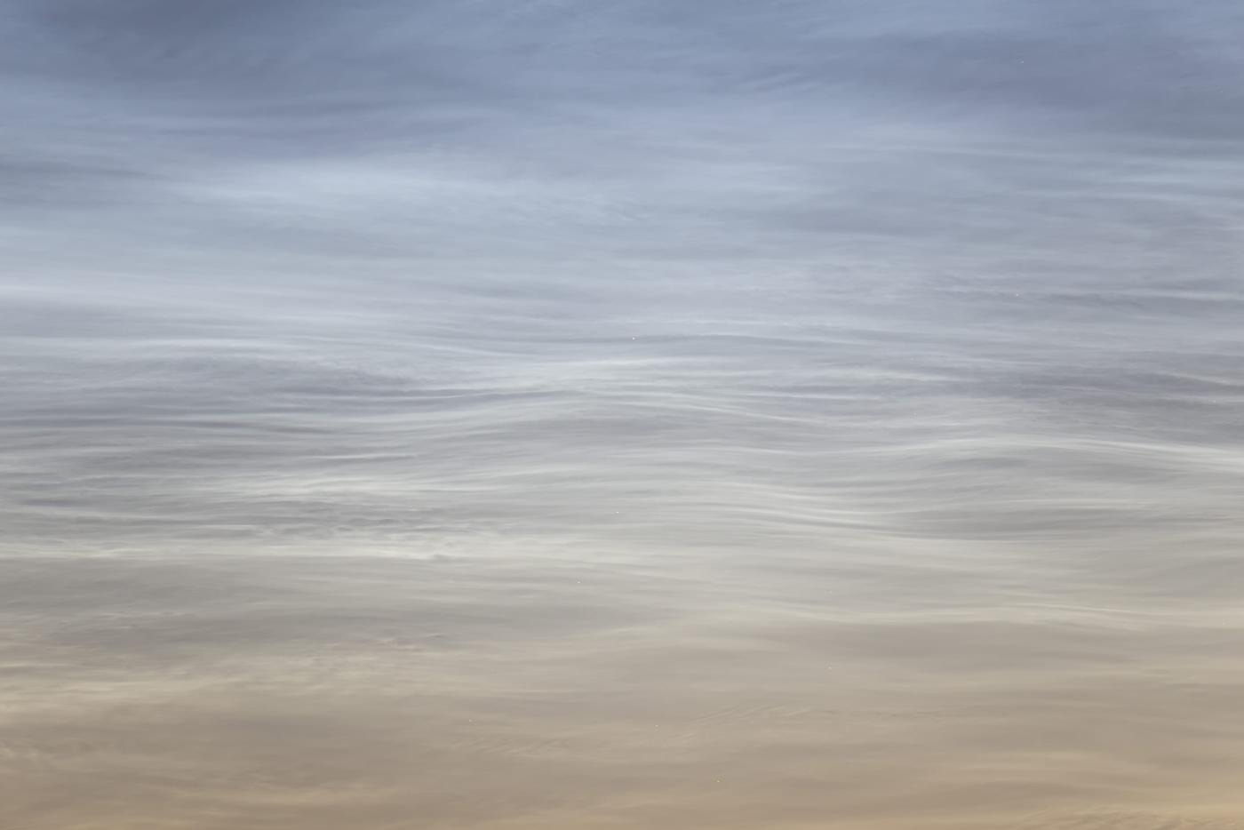 An image showing 'Silent Waves of the Sky: Noctilucent Clouds by Mikko Silvola'