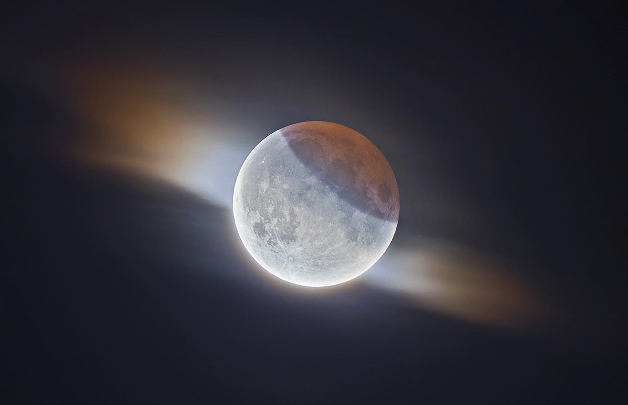 An image showing 'HDR Partial Lunar Eclipse With Clouds'