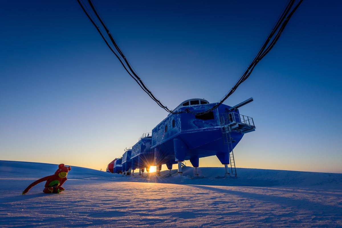 Image shows a base in snow, with the sun rising behind it
