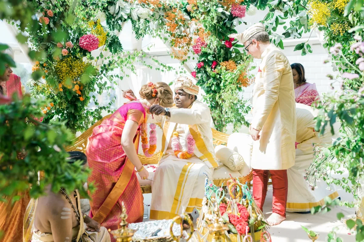 An Asian wedding ceremony with lavish floral arrangements.