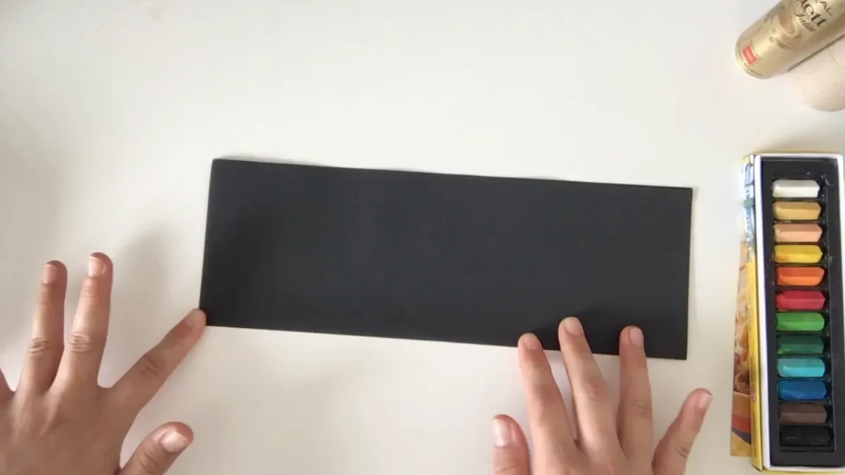 Hands holding piece of black paper